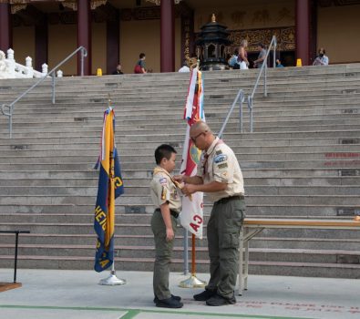 幼童軍Carson Che(左)逐一跨越由17片木板組成的橋，象徵童軍成長過程中的不同階段。