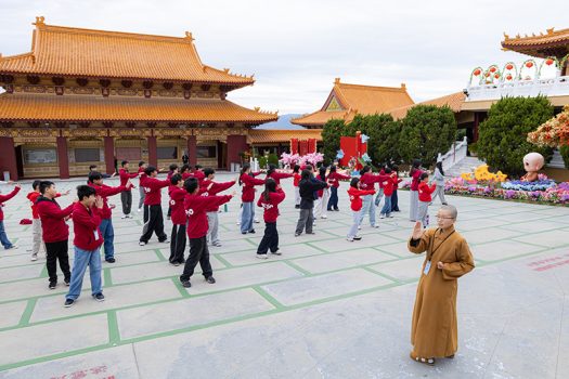 二單監院知行法師(左)帶領學員進行晨起暖身活動。