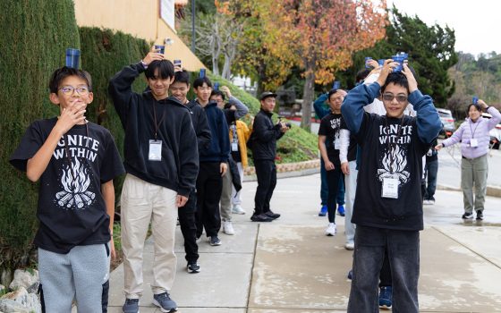 青年透過將杯子平穩置於頭上緩步行走，練習將注意力安住於腳下與當下。