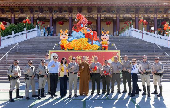 慧東法師(中)、蔡月琴會長(左6)、 分局長Melissa Hammond(左7)率領團隊、分局長Glenn Emery(右7) 率領團隊、Kenny Chang於成佛大道火馬主燈前合影。