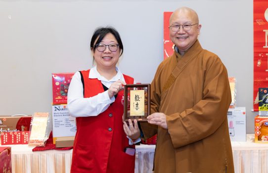 滿兆法師(右)頒發精美摸彩品予幸運中獎的周芝含老師。