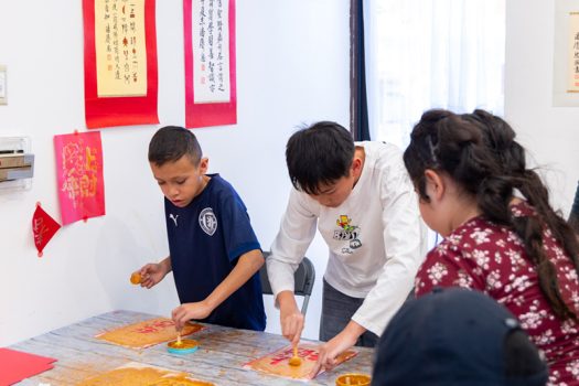 小朋友呼朋引伴一同體驗春聯拓印，玩得不奕樂乎。