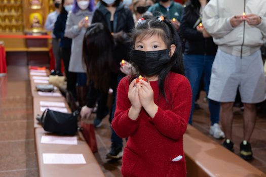 小朋友虔誠恭敬地雙手持燈。