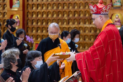 三師慧澤法師(右)將乾果盒交由齋主傳供。