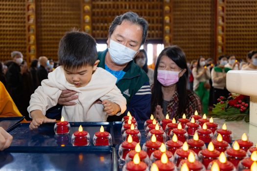 小朋友在家長陪同下，虔誠獻燈。