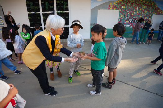 許珍蓉（左）分送多肉植物給小朋友。
