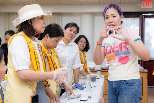 嚴錦泉（蓓兒）示範「咖啡渣結緣吊牌」塑膠模具的使用方法。