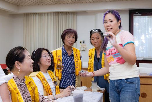 嚴錦泉（蓓兒）示範「咖啡渣結緣吊牌」金屬模具的使用方法。