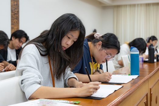 青年學子專注地手抄《心經》。