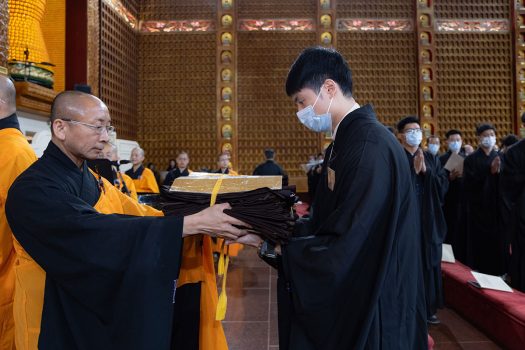 男眾戒子由佛光緣美術館主任慧軒法師(左)協助傳衣。